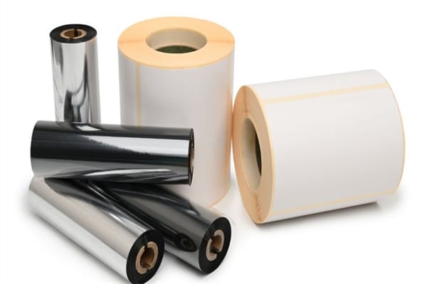 Rroll wax ribbon for thermal transfer printer in core and thermal labels on white background