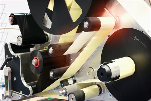 Fragment of the conveyor of sticking labeling machine. Abstract industrial background.