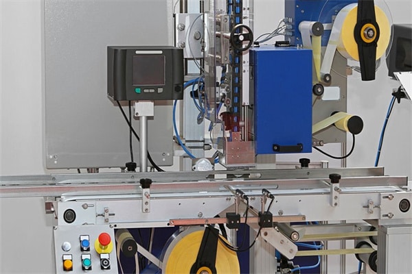 Labeling machine with conveyor belt in factory
